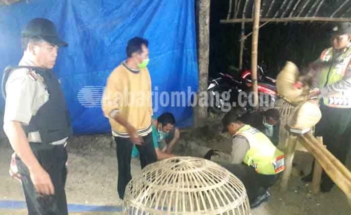 Petugas saat mengamankan barang bukti yang ditinggal kabur para penjudi