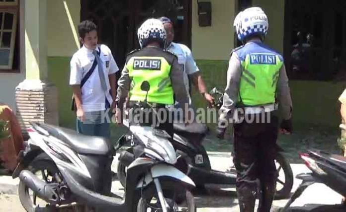 Petugas saat mengamankan pelajar yang nekad konvoi kelulusan di Jalan Raya Mojoagung Kabupaten Jombang