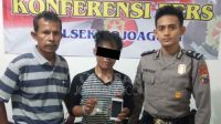 Tersangka Kris bersama barang buktinya, saat dirilis petugas di Polsek Mojoagung, Jombang.