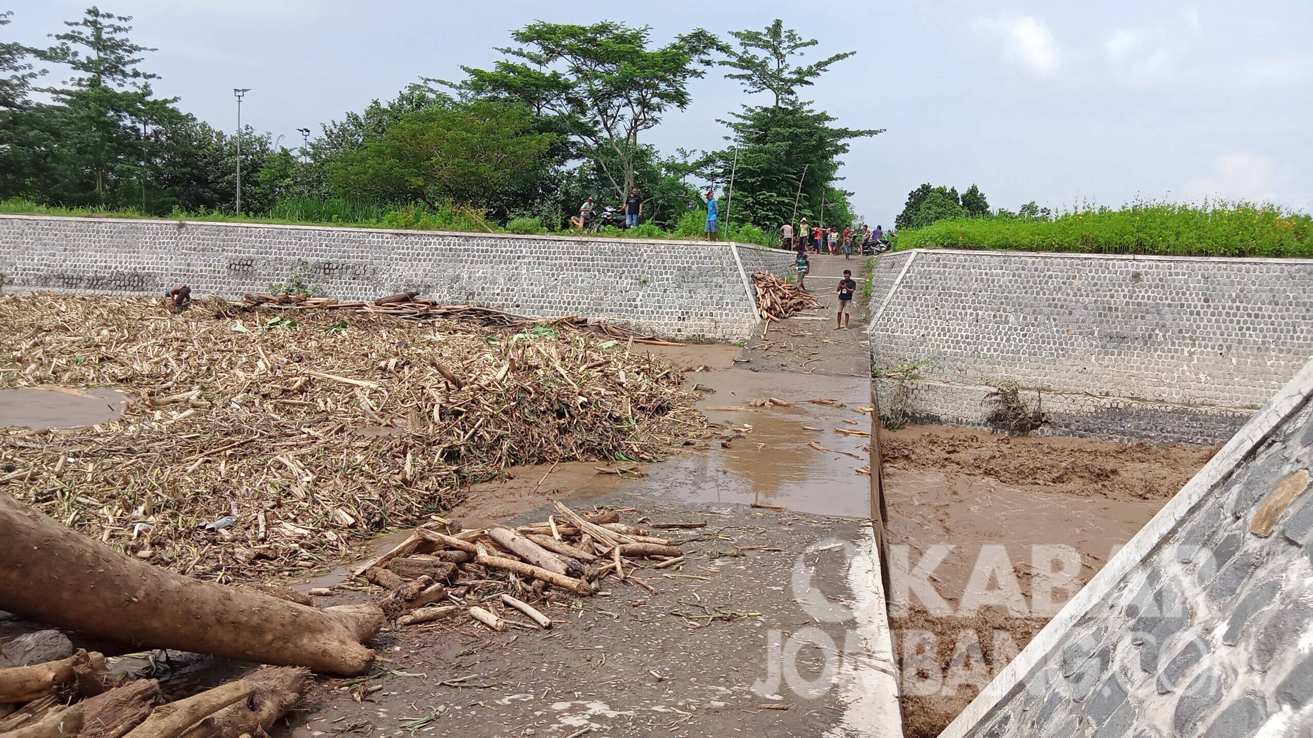 Tumpukan bongkahan kayu dan sampah memenuhi jembatan sungai kali Konto Barongsawahan, Kecamatan Bandarkedungmulyo, Kabupaten Jombang, Kamis (7/1/2021).