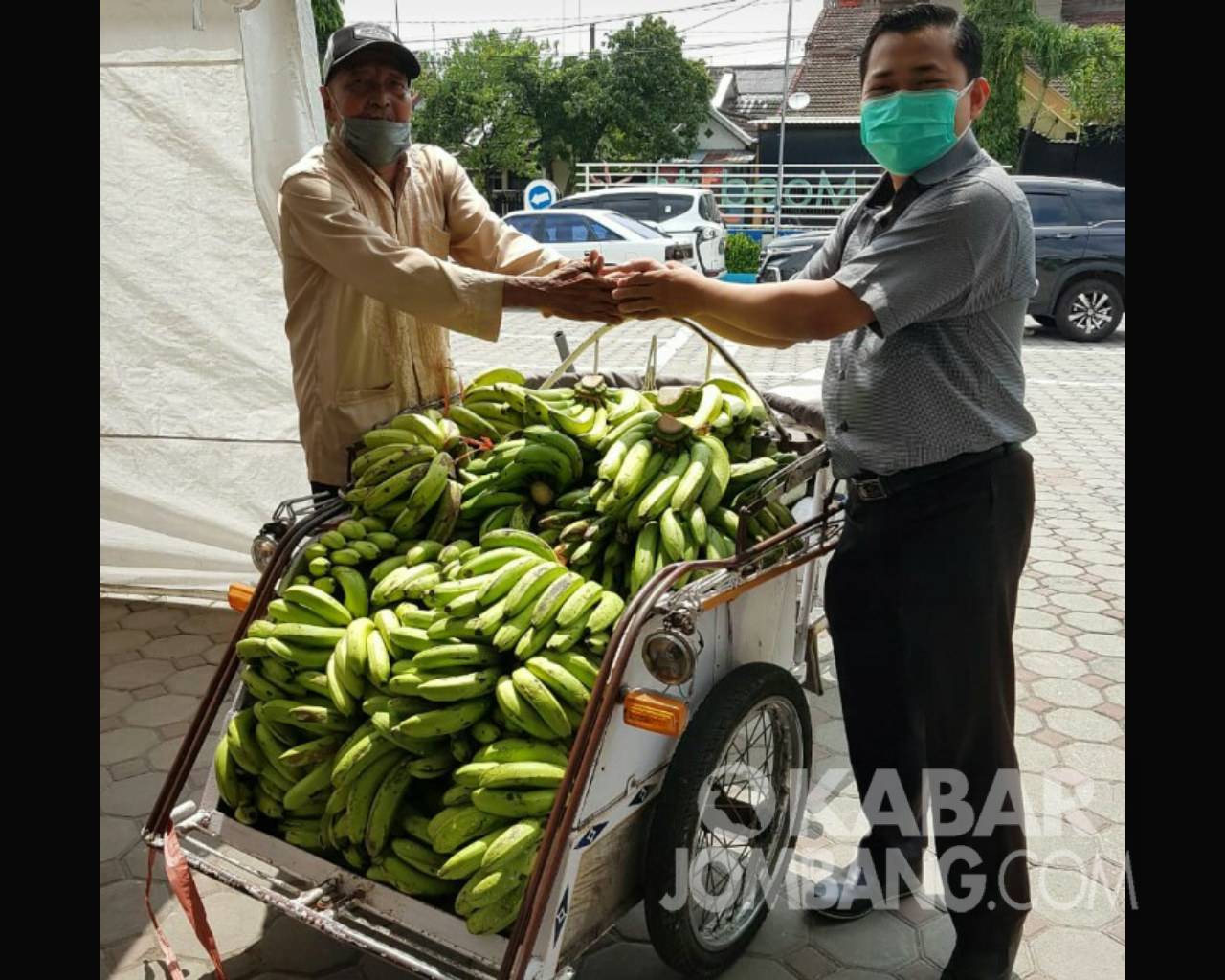 Kaseri (kiri)  saat memberikan pisang kepada pihak RS swasta di Jombang. Kabarjombang.com/Diana Kusuma/