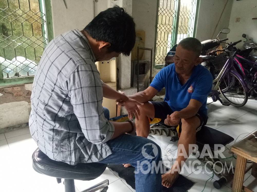 Andy Kwok (59) warga Desa Candimulyo, Kabupaten Jombang, mengobati pasien. KabarJombang.com/Diana Kusuma/