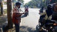 Mbah Ajijan saat beraksi dengan alat gitar kentrungnya di area traffic light di Jombang.