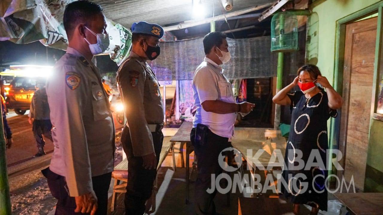 Petugas gabungan saat menggelar patroli penegakan prokes di wilayah Kecamatan Diwek, Jombang, Senin (30/8/2021) malam.