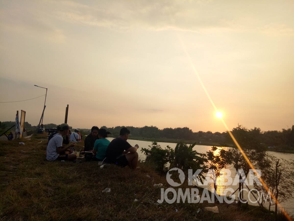 Menikmati keindahan matahari terbenam di Brantas Megaluh, Jombang, Minggu (1/8/2021). KabarJombang.com/Diana Kusuma/