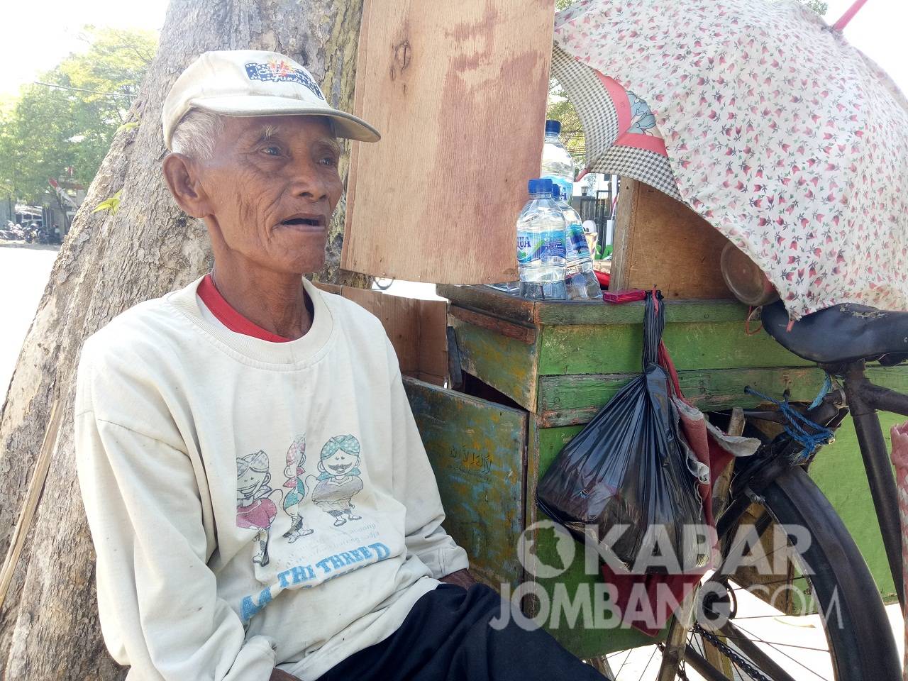 Sutrisno pria berusia 73 tahun warga Kelurahan Kepanjen, Kabupaten Jombang tetap berjuang mengais rezeki dengan berjualan rokok dan air mineral di pinggir jalan. KabarJombang.com/Diana Kusuma Negara/