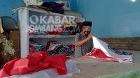 Alfan Efendi pengrajin bendera di Jombang saat merapikan hasil karyanya di kediamannya. KabarJombang.com/M Faiz H/