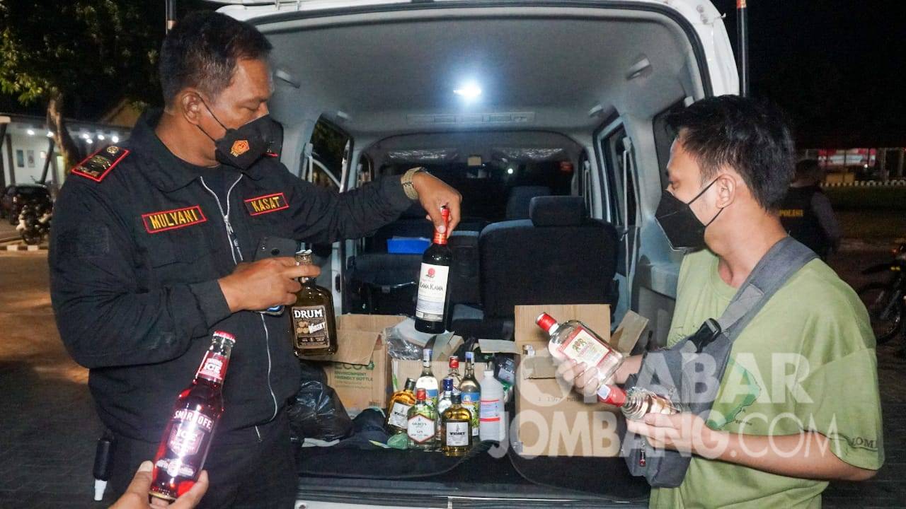 Kasat Sabhara Polres Jombang, Iptu Mulyani (kiri) mengamankan puluhan botol miras saat patroli Prokes.