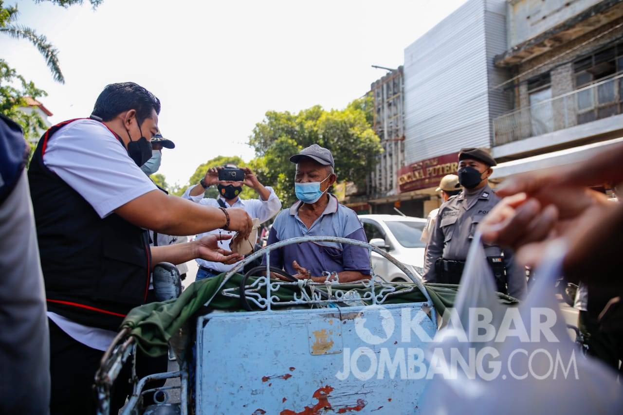Polisi membagikan makanan yang dibeli dari PKL kepada tukang becak di Jombang, Rabu (13/10/2021). KabarJombang.co,/Istimewa/