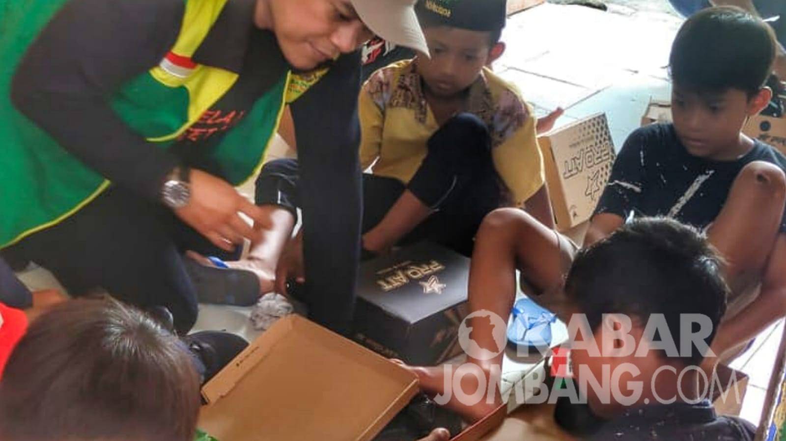 Anak-anak di desa pelosok Jombang mencoba sepatu yang diberikan Baznas, Minggu (29/5/2022). KabarJombang.com/Istimewa/