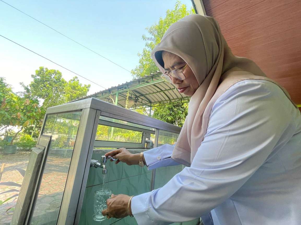 Kepala SMPN 1 Kudu, Srimudayani Dewi Astutik saat mengambil air langsung dari kran yang bisa diminum